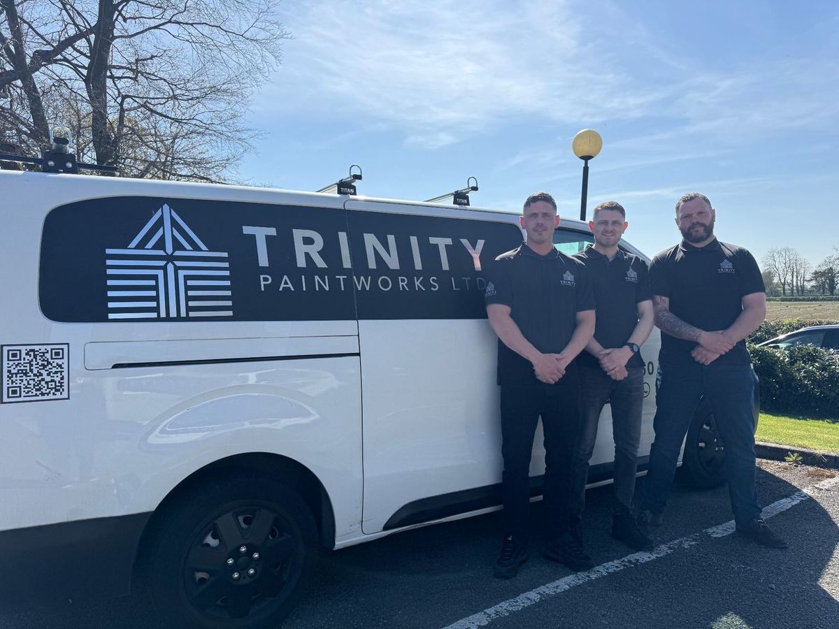 Trinity Paintworks directors standing beside one of our vans